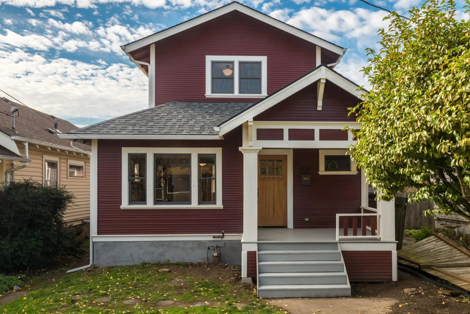 Custom craftsman home exterior with red siding and front porch