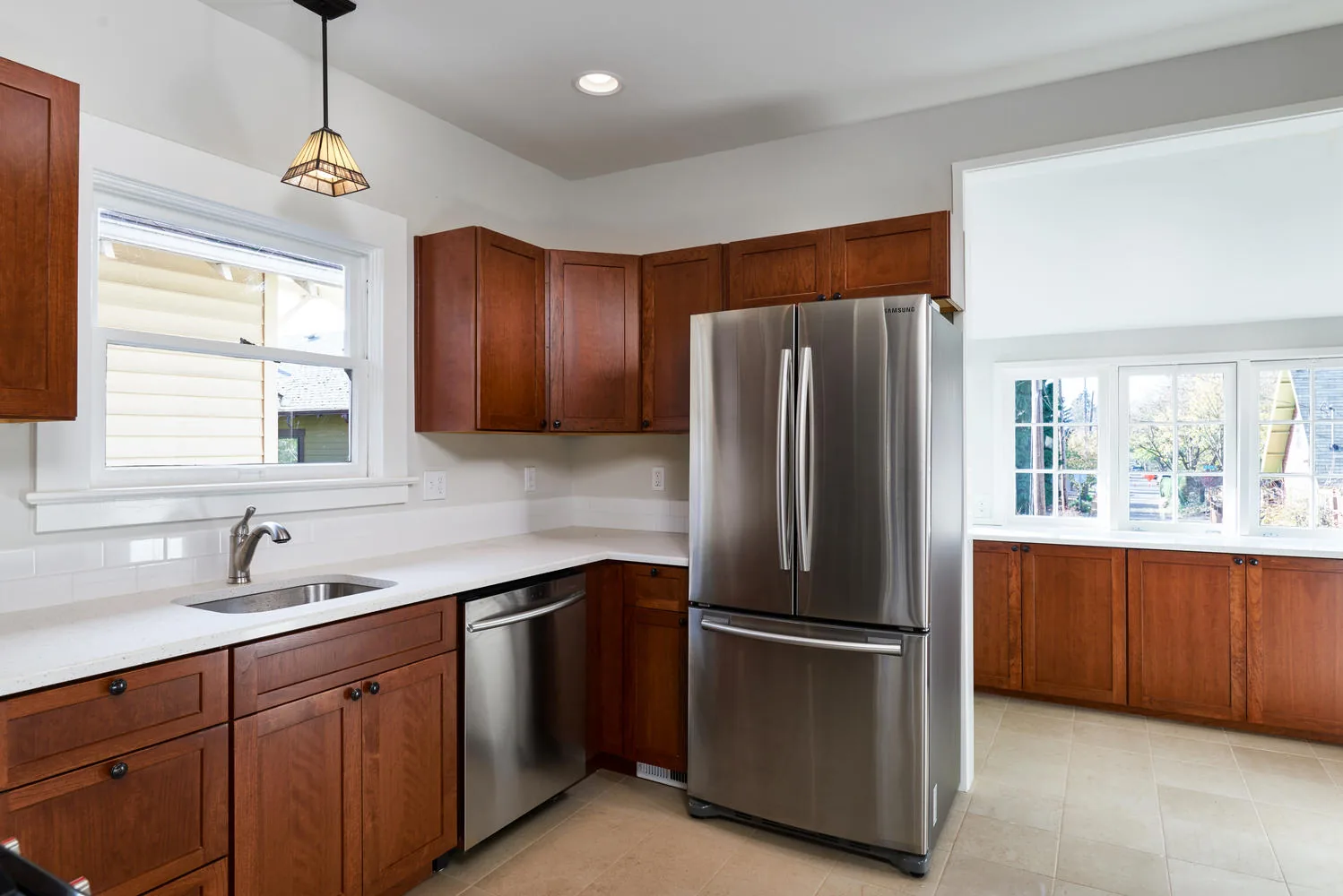 Custom-build kitchen with wood cabinetry and statement pendant light